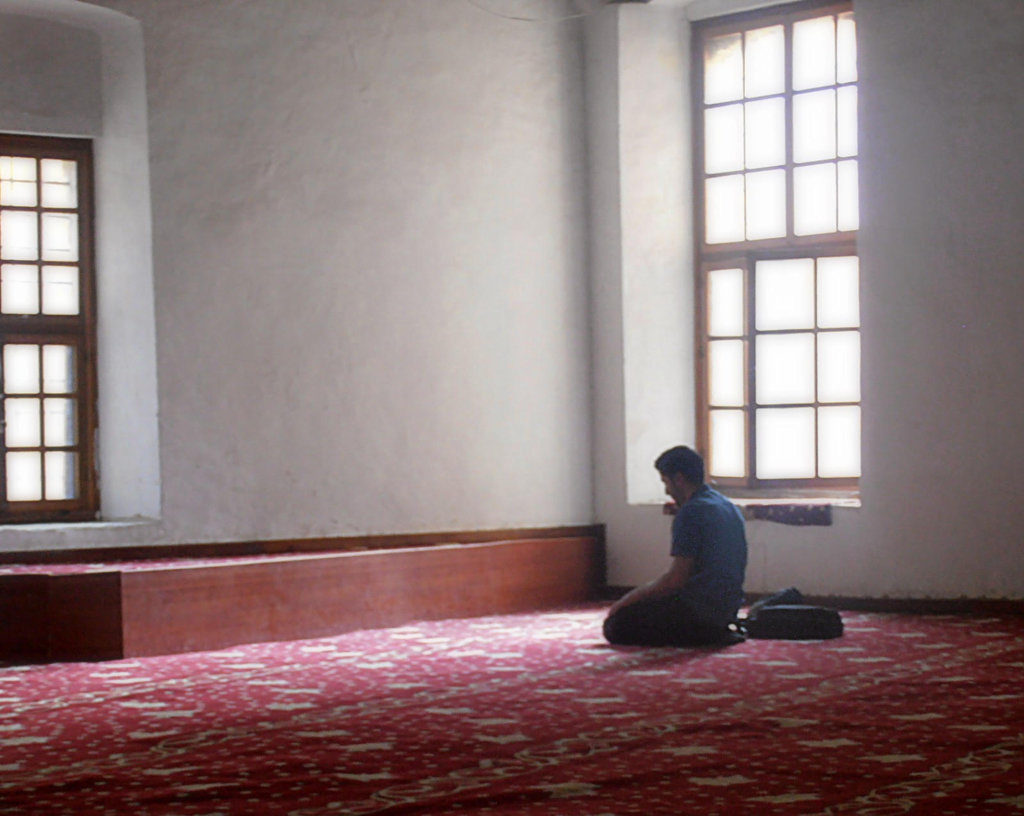 Un ragazzo prega trai raggi di luce della moschea di Selimiye Nicosia Cipro del Nord